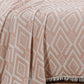 Crea 3-layer jacquard muslin blanket in terracotta, 100% cotton, draped elegantly on a bed.